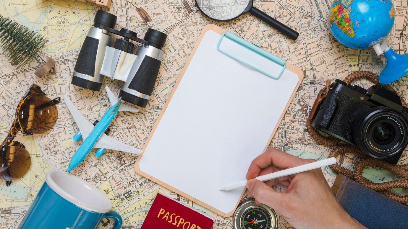 hand writing folder surrounded by travel elements
